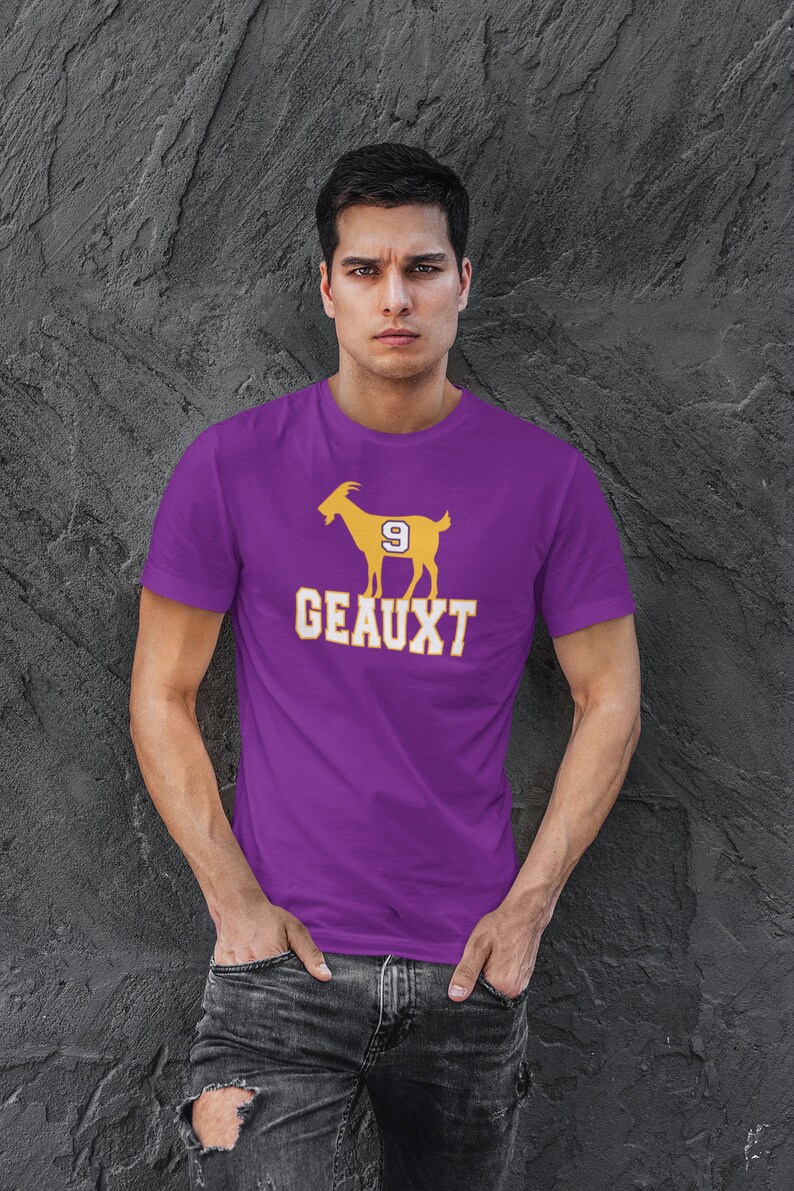May include: A purple t-shirt with a yellow silhouette of a goat with the number 9 on its side and the word "GEAUXT" printed below.