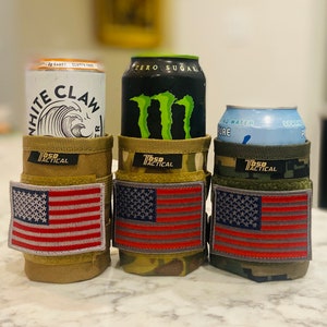 Puede incluir: Tres portavasos con parches de la bandera estadounidense. Los portavasos est&aacute;n hechos de tela de camuflaje y est&aacute;n dise&ntilde;ados para sostener una lata est&aacute;ndar de 355 ml. Los portavasos est&aacute;n etiquetados como "T650 Tactical".