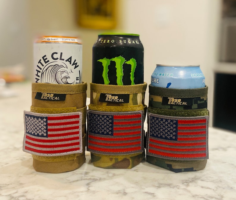 Puede incluir: Tres portavasos con parches de la bandera estadounidense. Los portavasos est&aacute;n hechos de tela de camuflaje y est&aacute;n dise&ntilde;ados para sostener una lata est&aacute;ndar de 355 ml. Los portavasos est&aacute;n etiquetados como "T650 Tactical".
