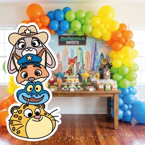 May include: A Zootopia-themed party scene with colorful balloons and a table laden with sweets. Character cutouts of Judy Hopps, Nick Wilde, and others are in the foreground. The backdrop features a cityscape and the text "Zootropolis Sweets."