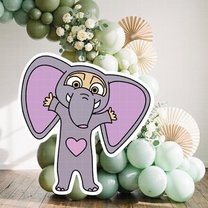 Puede incluir: Una pegatina de elefante de dibujos animados con un cuerpo gris, grandes orejas moradas y un coraz&oacute;n rosa en el pecho. El elefante sonr&iacute;e con los brazos abiertos. El fondo presenta un arco de globos en tonos verdes y blancos, y abanicos de papel.