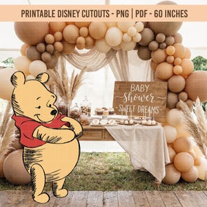 Peut inclure: Décor de fête prénatale avec une découpe de Winnie l'Ourson. La scène comprend une pancarte en bois avec l'inscription "Baby Shower - Sweet Dreams", une table avec des friandises et une arche de ballons aux tons neutres. Le texte en haut indique "Printable Disney Cutouts - PNG | PDF - 152 cm".