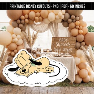 May include: A Pluto cutout on a cloud is in the foreground of a baby shower scene. The background features a balloon arch in shades of brown and beige, a wooden sign that reads "Baby Shower - Sweet Dreams", and a table with treats.