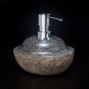 May include: A gray stone soap dispenser with a chrome pump. The dispenser has a rounded, pebble-like shape.