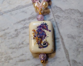 Collana di perline viola con ciondolo cavalluccio marino in ceramica
