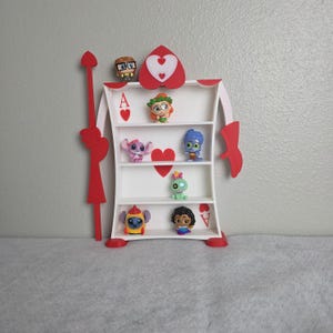 May include: A white and red decorative shelf in the shape of a playing card, with the Ace of Hearts design. The shelf is filled with small character figurines. The shelf is approximately 18 inches tall.