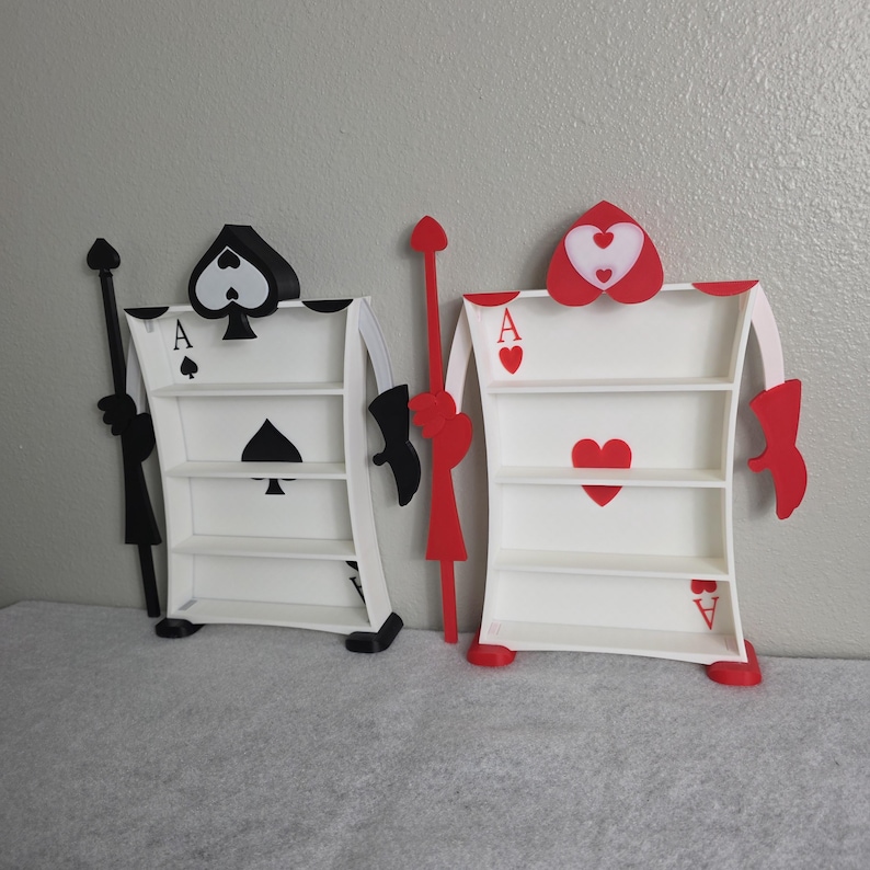 May include: Two decorative Ace of Spades and Ace of Hearts card-shaped shelves. The Ace of Spades shelf is black and white, while the Ace of Hearts shelf is red and white. Each shelf has three levels for displaying items.
