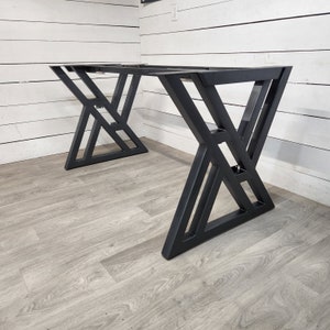 May include: Black metal table legs with a geometric design. The legs are made of sturdy metal and have a black finish.
