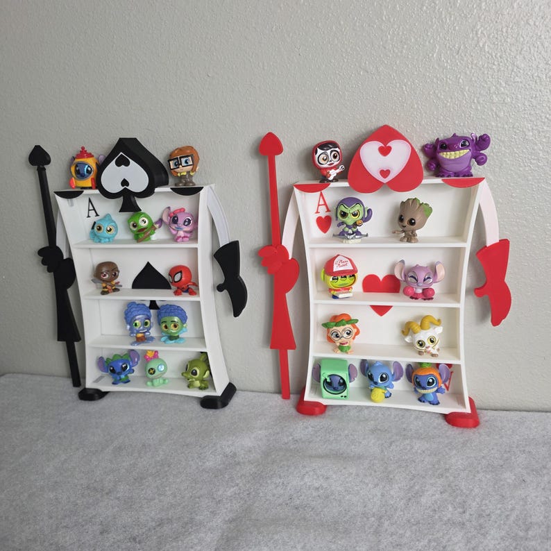 May include: Two decorative shelves shaped like playing card suits, one black spade and one red heart, each with three shelves holding various character figurines. The shelves are white with black and red accents, and the figurines are colorful.