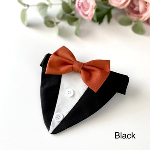 May include: A black and white tuxedo-style pet bandana featuring a rust-colored fabric bow tie attached at the top. The front panel is white with two small white buttons sewn vertically down the center, framed by black fabric sides. The word Black is printed in the bottom right corner.