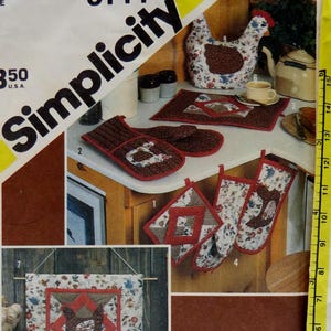May include: Simplicity pattern 6144 featuring a variety of kitchen items with a chicken theme. Includes oven mitts, pot holders, a tea cozy, and a decorative wall hanging. The pattern is marked "One Size".