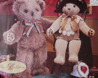 May include: A vintage Vogue Craft sewing pattern for making two teddy bears. The pattern is number 9603 and is designed by Linda Carr. One bear is wearing a hat and a lace collar, while the other bear is wearing a striped ribbon around its neck.