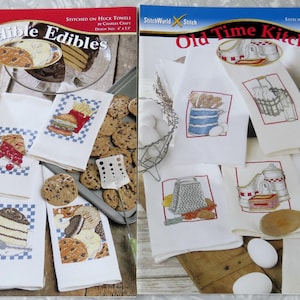 May include: Two cross-stitch pattern books titled "Incredible Edibles" and "Old Time Kitchen" with matching kitchen towels. The towels feature embroidered images of food items like bread, cake, and a burger, and kitchen tools.