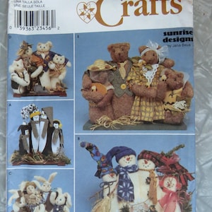 May include: A Simplicity Crafts sewing pattern envelope 8938 featuring Sunrise Designs by Jana Beus. The cover displays illustrations of fabric dolls including cats, bears, penguins, rabbits, and snowmen dressed in various outfits and accessories.