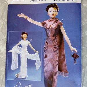 May include: A white ceramic mug with a black handle and the text "But First, Coffee" in a black, bold font. The mug is sitting on a white surface. The mug is approximately 4 inches tall.