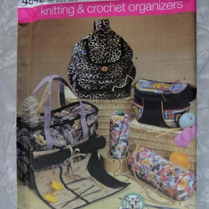 May include: Simplicity knitting and crochet organizer patterns. The image shows various bags and cases for storing knitting and crochet supplies. The bags have floral, butterfly, and leopard print designs. The pattern number is 4542.