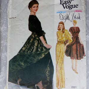 May include: A Very Easy Vogue sewing pattern envelope, number 2221, featuring an American Designer Original by Edith Head. The cover displays a photograph of a long, dark green skirt with a gold leaf pattern and a black top, alongside two illustrations.