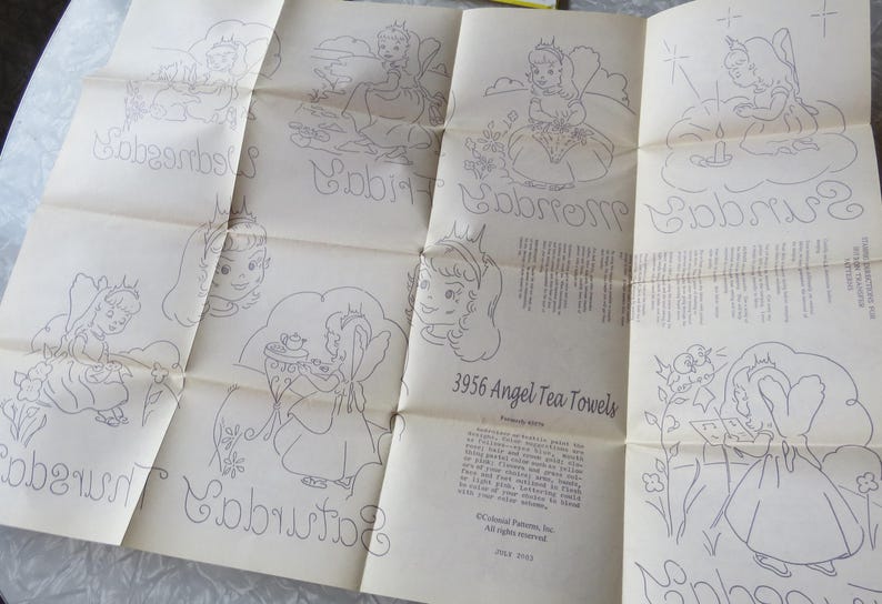 May include: A vintage paper pattern for 3956 Angel Tea Towels, featuring line drawings of angels and days of the week in cursive. The paper is off-white with faded ink, showing signs of age.
