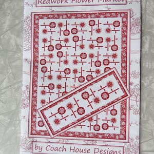 May include: A white and red pattern for a quilt, titled "Redwork Flower Market" by Coach House Designs. The design features a repeating floral pattern in red on a white background, with a smaller rectangular design on top.