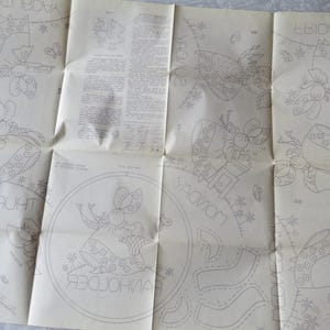 May include: Vintage sewing pattern with outlined illustrations of a bonneted figure with a basket, surrounded by floral and butterfly motifs. The pattern includes text with days of the week, and other instructions.