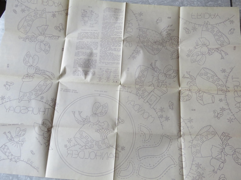 May include: Vintage sewing pattern with outlined illustrations of a bonneted figure with a basket, surrounded by floral and butterfly motifs. The pattern includes text with days of the week, and other instructions.