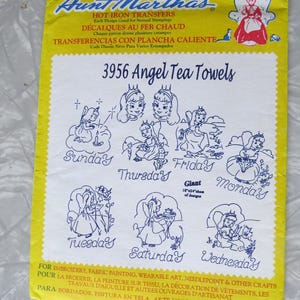 May include: A yellow and white Aunt Martha's iron-on transfer sheet for embroidery. The sheet features the text "3956 Angel Tea Towels" and illustrations of angels for each day of the week. The sheet is 45.7cm x 61cm.