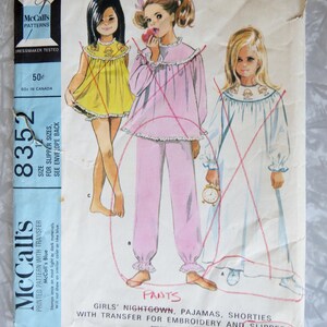 May include: Vintage McCall's sewing pattern for girls' nightgown, pajamas, shorties, and slippers. The pattern includes a transfer for embroidery. The pattern number is 8352. The pattern is printed on a blue background with white text.