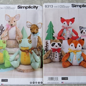 May include: Two Simplicity sewing pattern envelopes, 8311 and 8313, featuring illustrations of stuffed animals. Envelope 8311 shows two kangaroos and two frogs. Envelope 8313 displays two foxes and two raccoons, all wearing small fabric vests and bows.