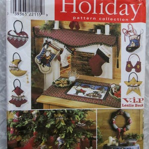 May include: A Simplicity Holiday pattern collection envelope, number 8366, featuring instructions for sewing Christmas-themed fabric ornaments, stockings, a mantel runner, a tree skirt, a wreath, and a tablecloth with winter and holiday motifs.