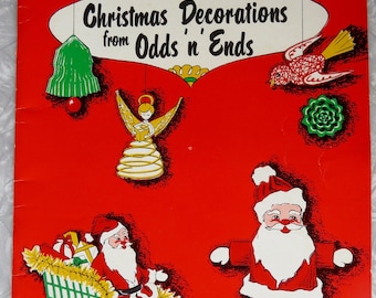May include: A vintage Christmas-themed book cover with a red background. The cover features illustrations of Santa Claus, angels, and Christmas ornaments. The title reads "Christmas Decorations from Odds n' Ends."