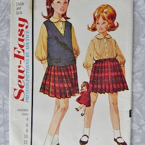 May include: A vintage sewing pattern envelope labeled 3269 size 10, featuring illustrations of two figures wearing yellow collared blouses and red plaid pleated skirts. One figure wears a dark blue vest. The text reads Sew-Easy Printed Patterns.