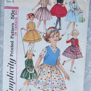 May include: Vintage Simplicity pattern 5092 for a girl's dress, size 8. The cover features illustrations of various dress designs, including a striped dress, a red skirt, and a blue dress. The pattern is printed and priced at 50 cents in the US and 60 cents in Canada.