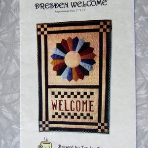 May include: A paper print titled "DRESDEN WELCOME" with a floral design and the word "WELCOME" in the center. The approximate size is 22 x 33 inches. A mug graphic is in the lower left corner.