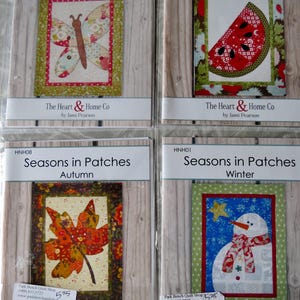 May include: Four quilting patterns for a seasonal quilt project. Each pattern features a different season: Springtime with a butterfly, Summertime with a watermelon slice, Autumn with a leaf, and Winter with a snowman. Each pattern is titled "Seasons in Patches" and includes the name of the season and the text "The Heart & Home Co. by Jami Pearson".