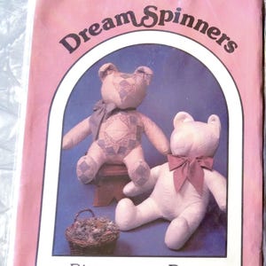May include: A sewing pattern packet titled Dream Spinners Bittersweet Bear by Great American Quilt Factory, Inc. The pink cover features two stuffed bears, one with a blue quilt pattern and bow, and one solid light color with a dark bow.