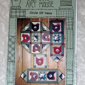 May include: A sewing pattern booklet titled Suzanne's Art House Circle Of Hens. The cover features a light green background with black line drawings of a birdhouse and thread spool. It displays four quilted projects with hen motifs.