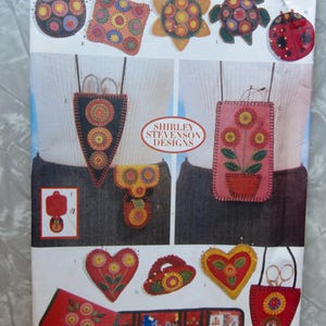May include: A Butterick 5454 sewing pattern envelope featuring Shirley Stevenson Designs. The cover displays various felt craft projects including small pouches, needle cases, heart-shaped ornaments, and decorative shapes like a turtle and ladybug.
