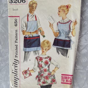 May include: Vintage Simplicity printed pattern 3206, featuring illustrations of aprons. The cover shows three figures wearing different apron designs, including striped and floral patterns. The text "SIMPLE TO MAKE" is visible.