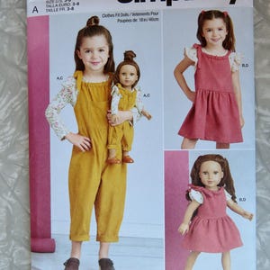 May include: Simplicity sewing pattern S9661 for clothes that fit 18-inch dolls. The pattern includes options for a jumpsuit and a dress. The cover shows a girl and her doll wearing the outfits. The pattern is designed and printed in the USA.