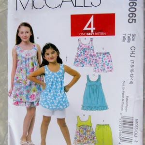 May include: A McCall's sewing pattern envelope, M6065, featuring illustrations of children's clothing. The pattern includes options for dresses, tops, and shorts. The size range is CHJ (7-8-10-12-14). The envelope is white with the McCall's logo.