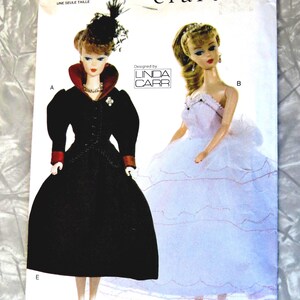May include: Vogue Craft pattern 7190 featuring two doll designs. One doll wears a black dress with a red collar and cuffs, the other a white dress. The pattern is designed by Linda Carr and is from the 1940s and 1950s.