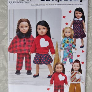 May include: A Simplicity S9439 sewing pattern envelope for 18-inch doll clothes. The cover features illustrations of dolls wearing various outfits, including a red plaid cape, heart-patterned dresses, floral sets, and sweaters with heart appliqués.