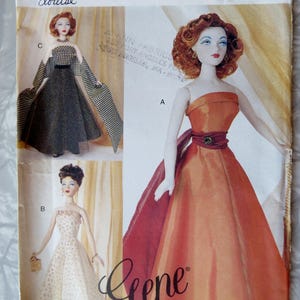May include: Vogue Doll Collection pattern featuring three doll designs. The main doll wears an orange strapless gown with a red sash. Other dolls are in a black and white checkered dress and a white dotted gown. The pattern number is 7381.