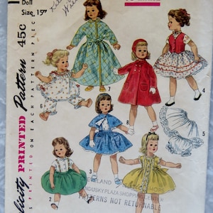 May include: A vintage sewing pattern for a 15-inch doll. The pattern includes instructions for making a dress, a coat, a skirt, a cape, and a pair of pants. The pattern is printed on a white background with a pink border. The pattern number is 1779 and the price is 45 cents. The pattern is titled "Simple to Make" and is from Simplicity.