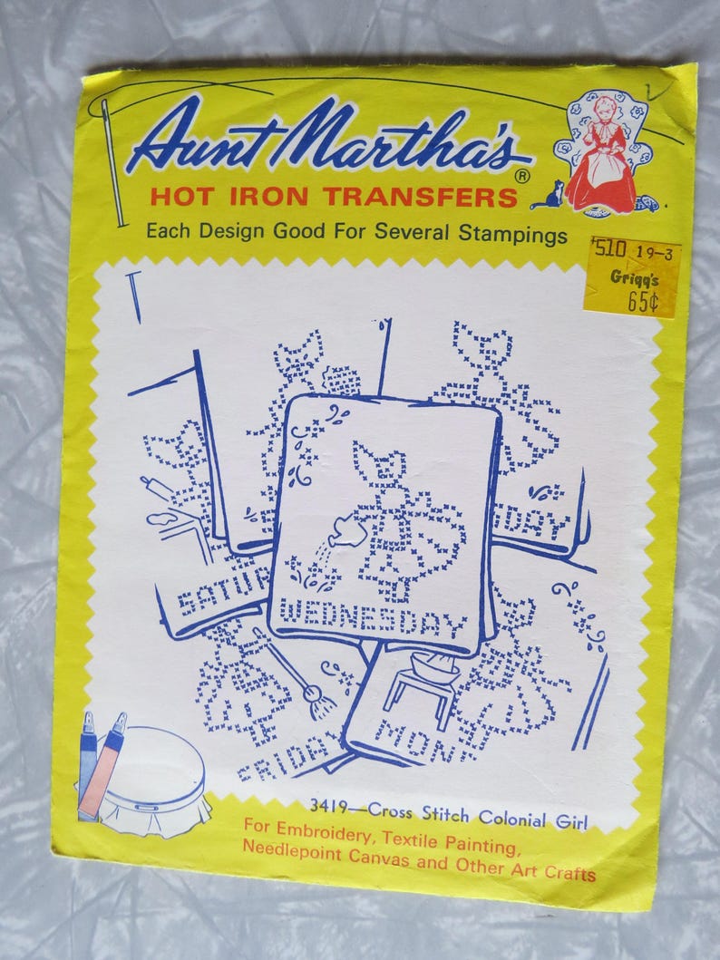 May include: A vintage Aunt Martha's Hot Iron Transfers package. The yellow and white package features blue cross-stitch designs for each day of the week. Includes the text "Cross Stitch Colonial Girl" and a price tag.