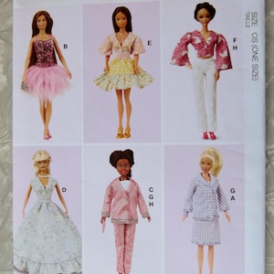 May include: A McCall's sewing pattern sheet featuring six doll designs. The dolls are dressed in various outfits, including a pink tutu, a floral dress, a pink suit, and a blue gingham skirt set. The pattern is size OS (one size) and designed and printed in the USA.