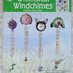 May include: A crochet pattern book for making whimsical windchimes. The cover features a colorful illustration of nine crocheted characters, including a cat, a frog, a flower, and a worm. The book is titled "Whimsical Windchimes" and is designed by Stacey Graham.
