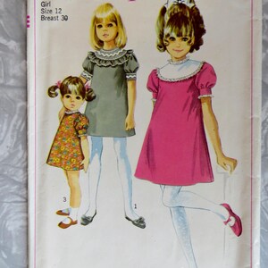 May include: Vintage Simplicity sewing pattern 7885 for girls' dresses, size 12, breast 30. The cover features illustrations of three girls in dresses, including a floral print, a gray dress, and a pink dress. The Simplicity logo is in pink.