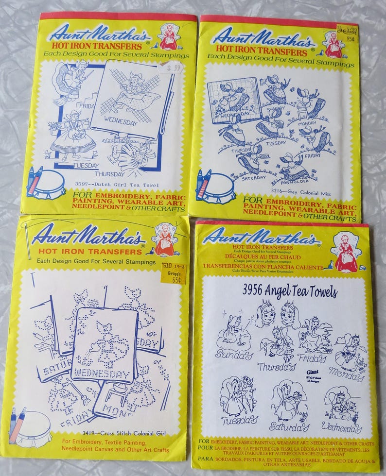 May include: Four vintage Aunt Martha's Hot Iron Transfer packets. Each packet has a yellow background with blue and white designs. The packets are labelled for embroidery, fabric painting, and other crafts. Designs include tea towels and colonial girl motifs.