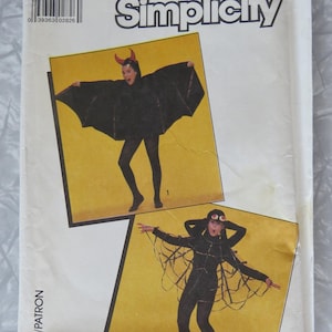 May include: A Simplicity sewing pattern envelope, number 8330, size B for boy/girl. The front displays two costume options: a black bat costume with red horns and a black spider costume with a web-like cape and headpiece with large red eyes.